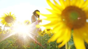 Happy little girl on the field of sunflowers sunlight in summer. beautiful sunset little girl in sunflowers. slow motion video. girl lifestyle teenager and sunflowers field concept agriculture