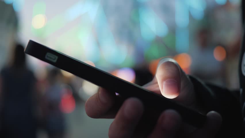 Close-up image of child hand using smartphone at night on city shopping street, search or social network concept, hipster man typing sms message to his friends. child holding a smartphone in his hand Royalty-Free Stock Footage #1015004110