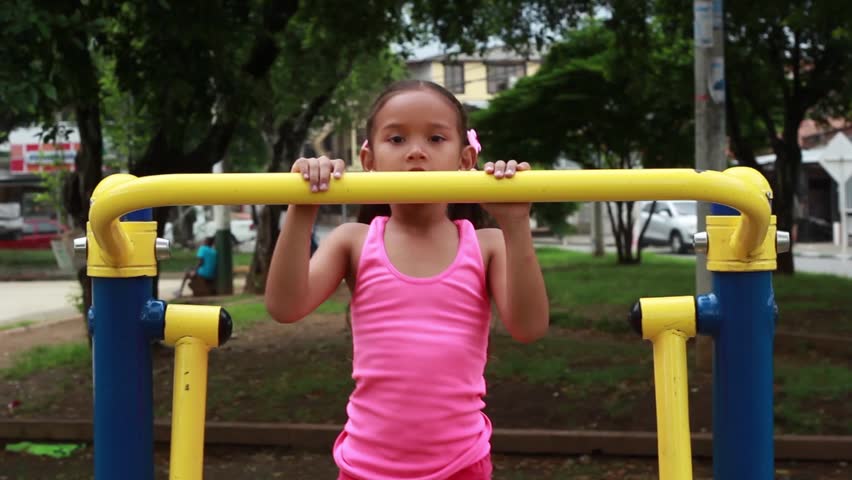 Cali, Colombia - July 03, 2018: Little girl strapping on helmet in Cali, Colombia; South AmericaCali, Colombia - July 03, 2018: