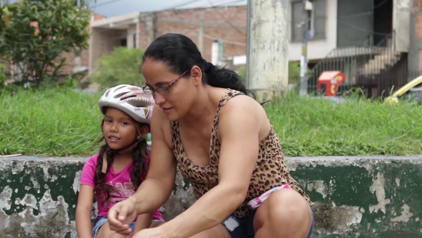 Cali, Colombia - July 03, 2018: Mom watching daughter jump in park in park in Cali, Colombia; South America