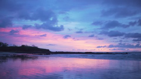 Out of focus background plate of gorgeous purple and blue sunset on the beach in Costa Rica for compositing or keying. Blurred or defocused shot of ocean sun set for green screen composite. 4k
