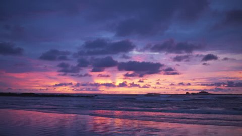 Out of focus background plate of orange, purple and blue sunset on the beach in Costa Rica for compositing or keying. Blurred or defocused shot of ocean sun set for green screen composite. 4k