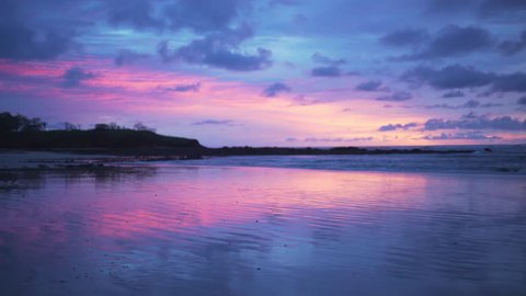 Beautiful out of focus background plate of purple and blue sunset on the beach in Costa Rica for compositing or keying. Blurred or defocused shot of ocean sun set for green screen composite. 4k