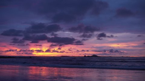 Out of focus background plate of beautiful orange, purple and blue sunset on the beach in Costa Rica for compositing or keying. Blurred defocused shot of ocean sun set for green screen composite. 4k