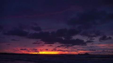 Out of focus background plate of beautiful purple and orange sunset on the beach in Costa Rica for compositing or keying. Blurred or defocused shot of ocean sun set for green screen composite. 4k