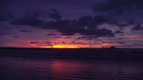 Out of focus background plate of deep purple and orange sunset on the beach in Costa Rica for compositing or keying. Blurred or defocused shot of ocean sun set for green screen composite. 4k