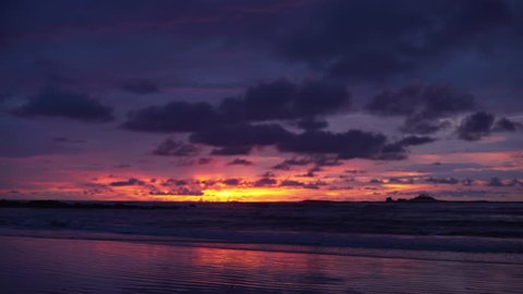 Pretty out of focus background plate of orange, purple and blue sunset on the beach in Costa Rica for compositing or keying. Blurred or defocused shot of ocean sun set for green screen composite. 4k