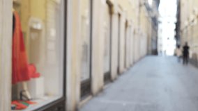 Small street scene with shopping store windows in Europe. Out of focus view of fashion store window on narrow street in Italy