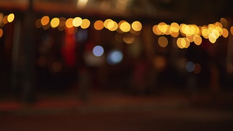 Out of focus background plate of city street with bokeh lights shot from sidewalk of downtown urban area. Blurry Video backdrop for green screen compositing. 4k