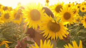 Happy portrait little girl on the field of sunflowers in summer. beautiful portrait little girl in sunflowers. lifestyle slow motion video. 