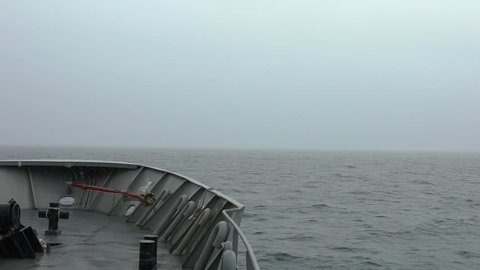 Navy ship sailing on a dark and rainy day