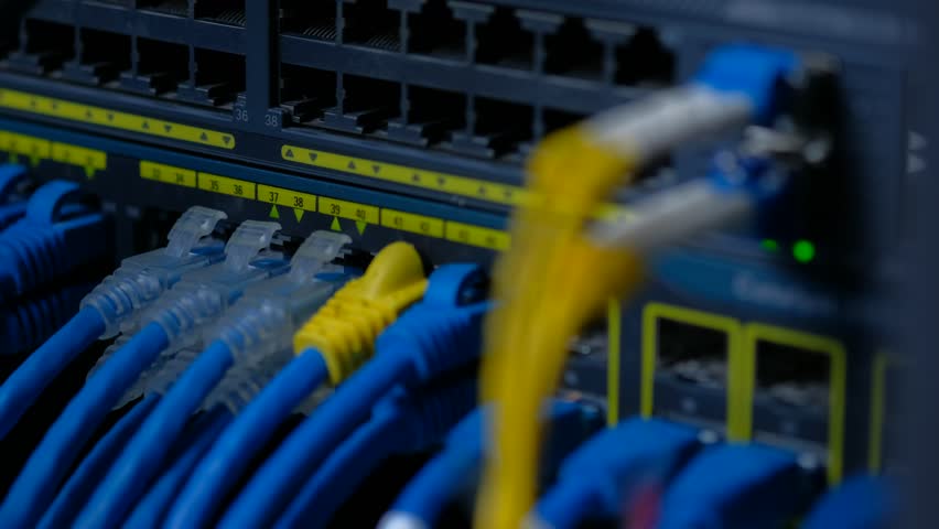 Zoom in. UTP and Fiber optic cable on Network gigabit switch for high speed network in data center room.