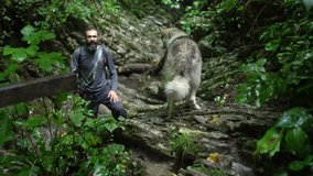 Blogger traveler shoots his dog's video by action camera in green forest at the mountains