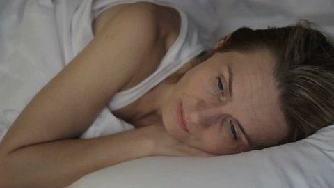 Thoghtful, lonely, upset woman can not fall asleep, having problems with sleep