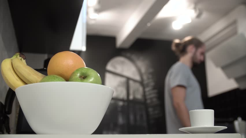 Man Pouring Coffee Into Cup At Modern Kitchen