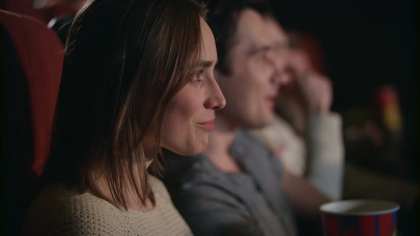 Smiling woman watching movie. Close up of beautiful girl laughing in cinema in slow motion. Boyfriend and girlfriend have fun at movie theater. Romantic date at cinema. Love couple watch comedy film | Shutterstock HD Video #1015060114