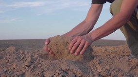 slow motion video of Human's hands hold earth dust. Drought, land without rain