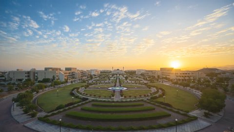 Aerial Time lapse of Oman beautiful landscape overlooking the beautiful Sultan Qaboos University garden at sunrise with rare clouds formation. Motion Timelapse Slide Up. 4K resolution.