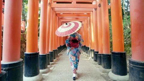 Asian women in traditional japanese kimonos walking at Fushimi Inari Shrine in Kyoto, Japan. 4K