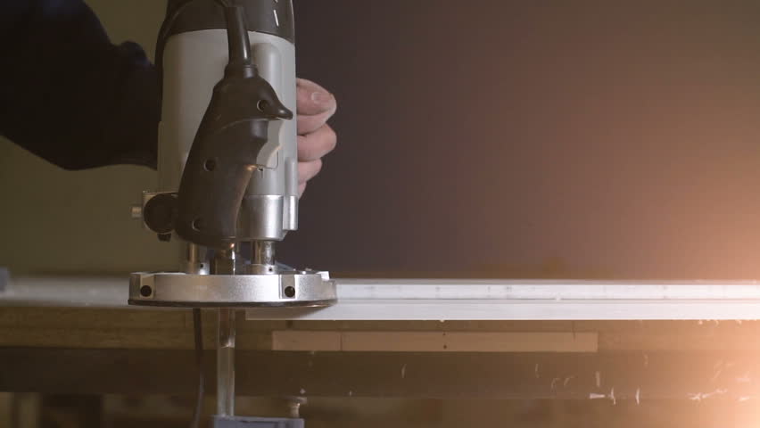 A circular saw close up works with a large bar slow motion. A lot of sawdust flies off when a round saw goes on wood. On a blue background a guy cleans a tree with a lot of chips closeup.