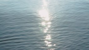 Clear sea water, sun sparks on the water surface. Ripple water surface reflecting the sunlight in the morning. Twinkle is shining on wave, outdoor on summer day. Abstract blurry background.