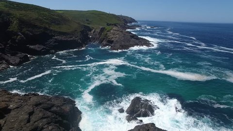 Drone footage of rocky coastline. Tracking shot of the rocky coast from Cornwall, UK.