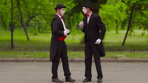 Two comical mimes do performance in the park