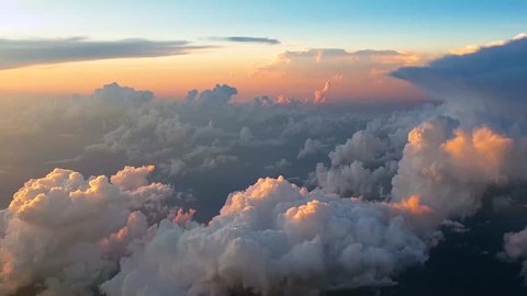 Flying over clouds at 30,000 feet at sunset