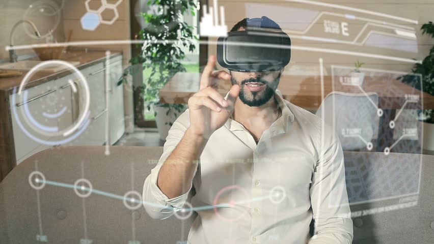 Handsome bearded arab man wears white shirt uses VR helmet with futuristic visual interface, slide gestures on hologram control panel sitting in the kitchen Royalty-Free Stock Footage #1015085164