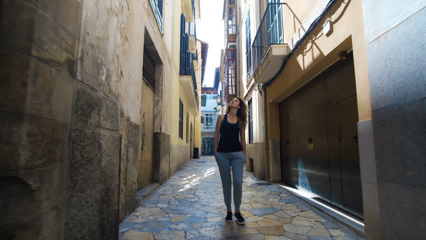 Rear view tourist woman Walking narrow streets of Barcelona Wearing cute summer dress enjoying European summer holiday travel vacation adventure