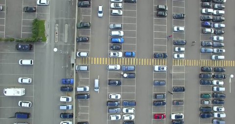 4k top down tracking shot of overground parking lot with empty slots traffic laws routing. Flight over high-level car park at shopping mall many automobiles driving camera sliding highway code
