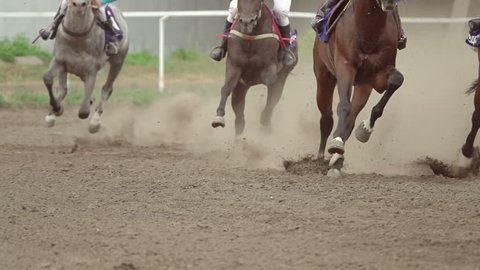 Horse racing at the racetrack. A group of riders pass the curve.Slow motion