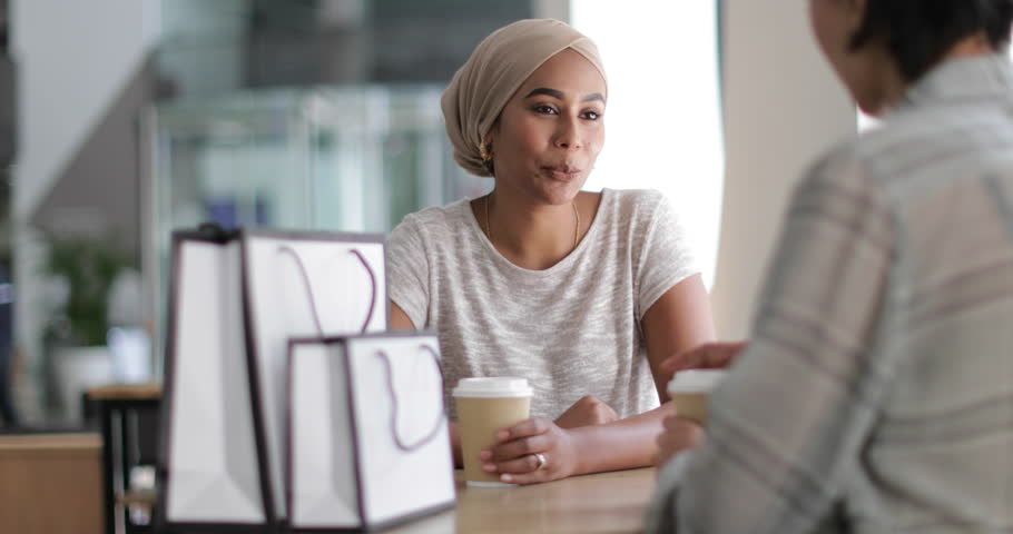 Female Muslim friends having coffee together in a shopping mall
