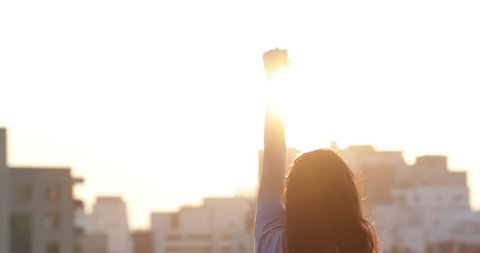 Woman raising her fist in the air in victory stance