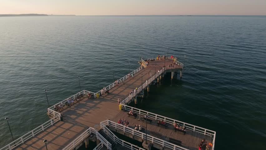 4K. Aerial view to the pier for yachts. People are walking on the pier for the day