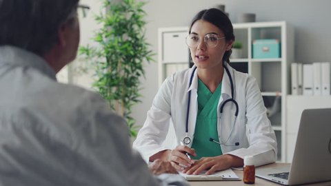 Doctor and patient are discussing at clinic - Βίντεο στοκ