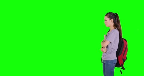 Confused female high school student walking back and forth while thinking in the studio. Shot in 4k resolution with green screen background