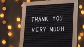 Black letter board with THANK YOU VERY MUCH Written on it with white letters. Camera rotating around the sign showing the beautiful bokeh balls in the background. - Powered by Shutterstock - Get 15% off with code: PIKWIZARD15