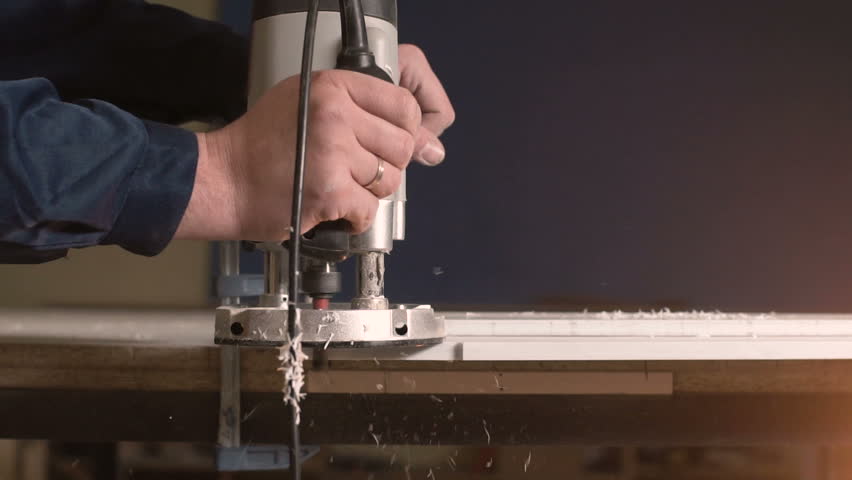 A circular saw close up works with a large bar. On a blue background a guy cleans a tree with a lot of chips closeup. A lot of sawdust flies off when a round saw goes on wood.