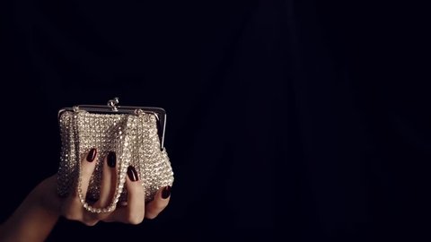 Woman hand holding vintage elegance-handbag decorated  with diamond isolated on black background. Handbag made of diamonds. Female sparkling glamour luxury silver diamond purse handbag.