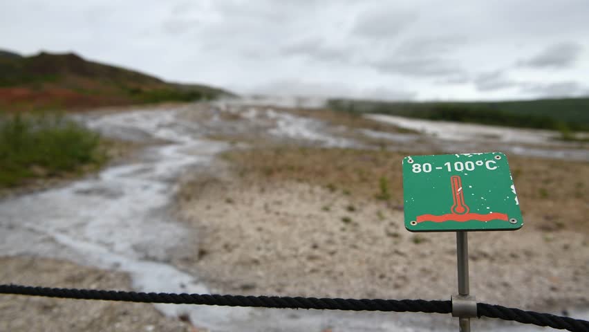Geysir with warning signs in fron. Haukadalur geothermal area, Iceland.