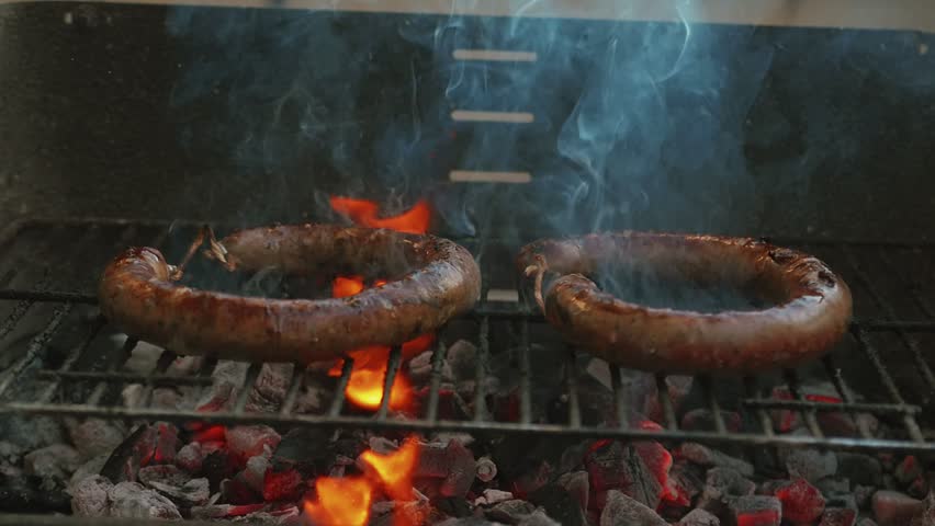 Slow Motion Homemade Sausage Barbecue Cooking And Smoking Closeup High Contrast Cooking Video Charcoal Fire Underneath Royalty-Free Stock Footage #1015174384