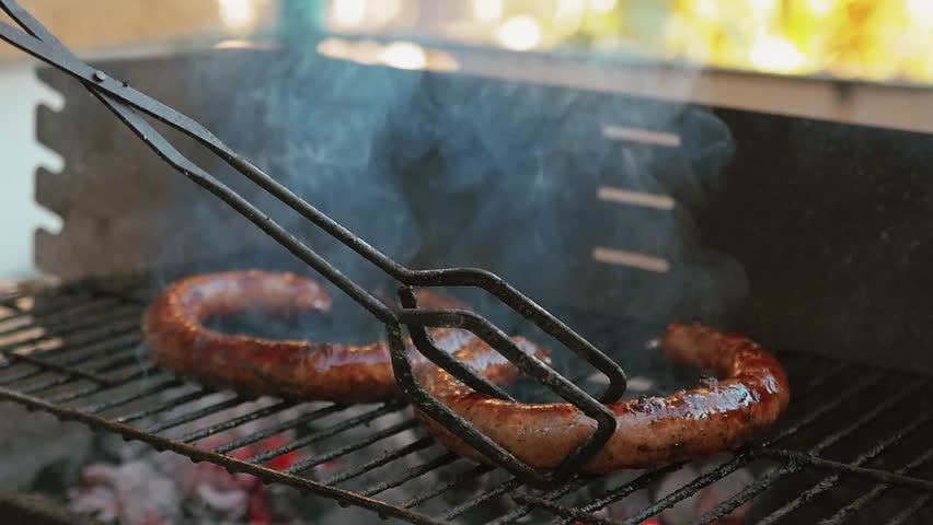 Slow Motion Turning With Grill Tweezers Homemade Sausage Barbecue Cooking And Smoking Closeup High Contrast Cooking Video Charcoal Fire Underneath Royalty-Free Stock Footage #1015174501