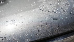 Waxed car hood surface washing with automatic pressure washer slow-mo video