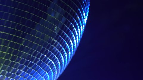 Mirror ball reflects colorful light. Close up
