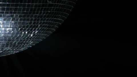 Mirror ball, also known as a disco ball, spinning against black. Close up