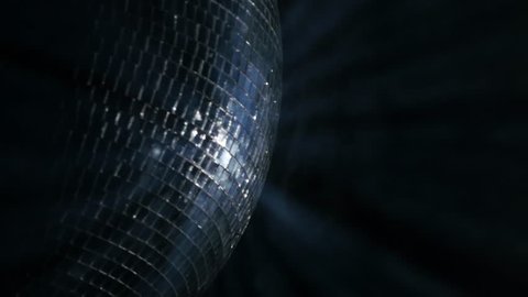 Mirror ball, also known as a disco ball, spinning against black. Close up