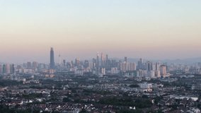 4K  Footage of Kuala Lumpur city view during dawn overlooking the city skyline and national landmarks from afar. Grainy video effect with motion blur effect.