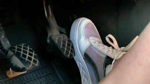 Girl on white sneakers shoes pressing car pedals 4k