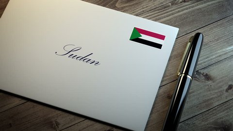 Country name written on a card or envelope in cursive font with a sleek pen on a wooden table surface under beautiful classy light. Stamp in the corner shows the flag of Sudan